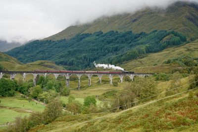 Steam train going over glenfinnan viaduct